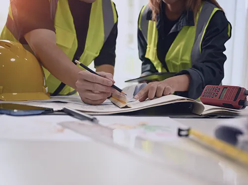 Not your normal ecommerce consultants - Two workers in high vis jackets collaborate on planning and implementing a project